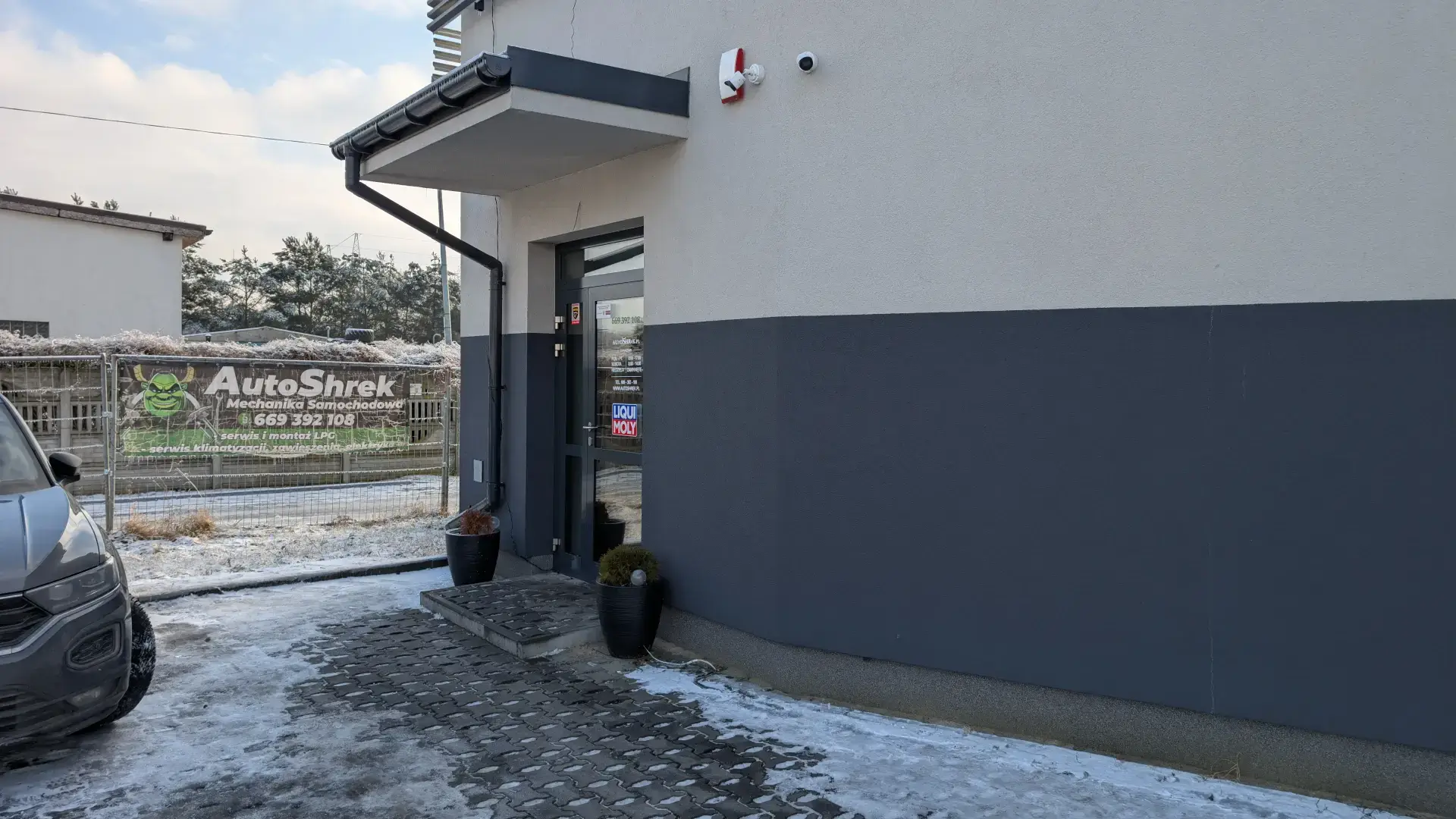 Wejście do biura obsługi klienta oraz baner reklamujący serwis i montaż instalacji LPG.