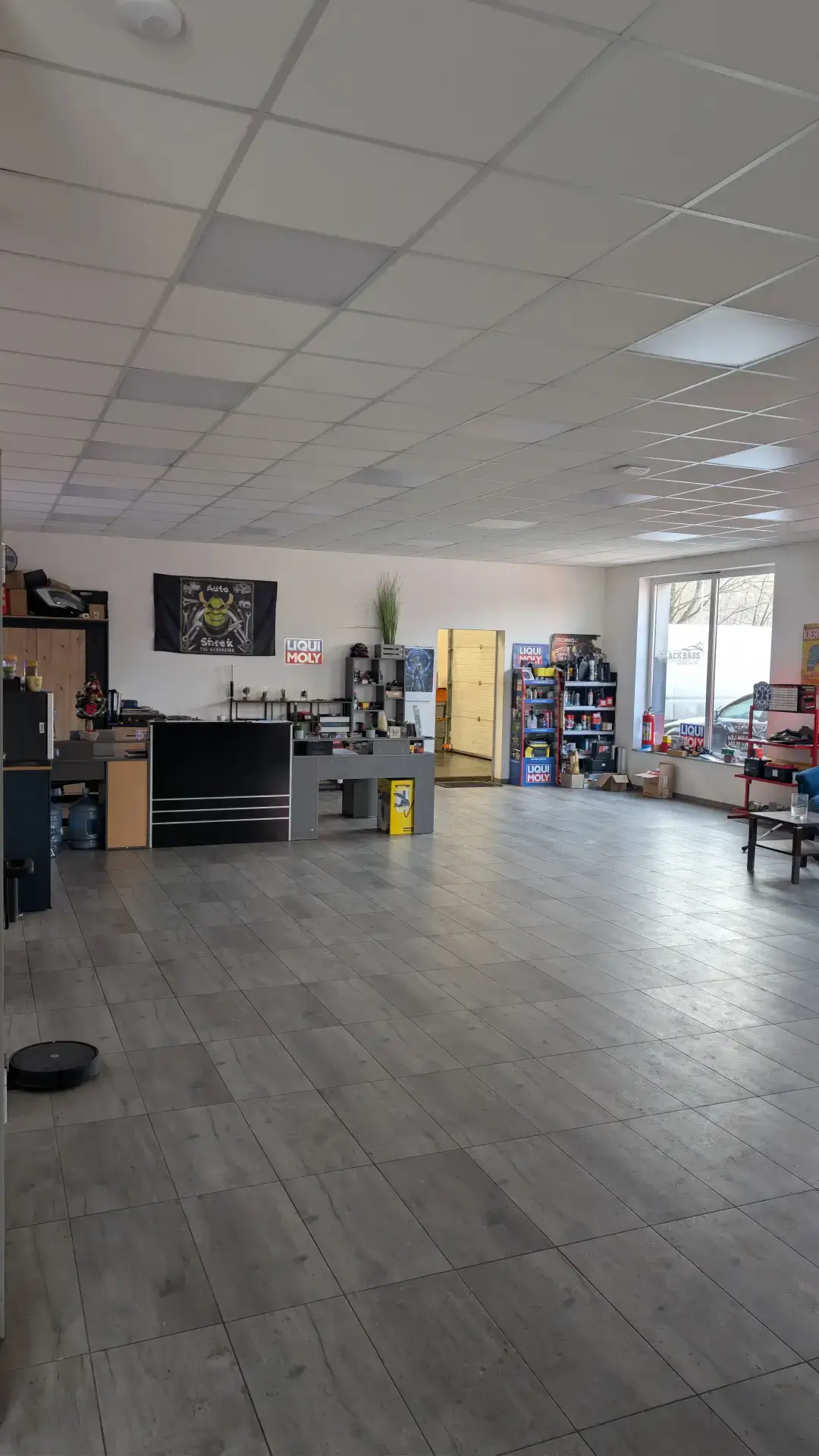 Nowoczesne, czyste wnętrze recepcji serwisu samochodowego z widoczną ekspozycją olejów Liqui Moly.