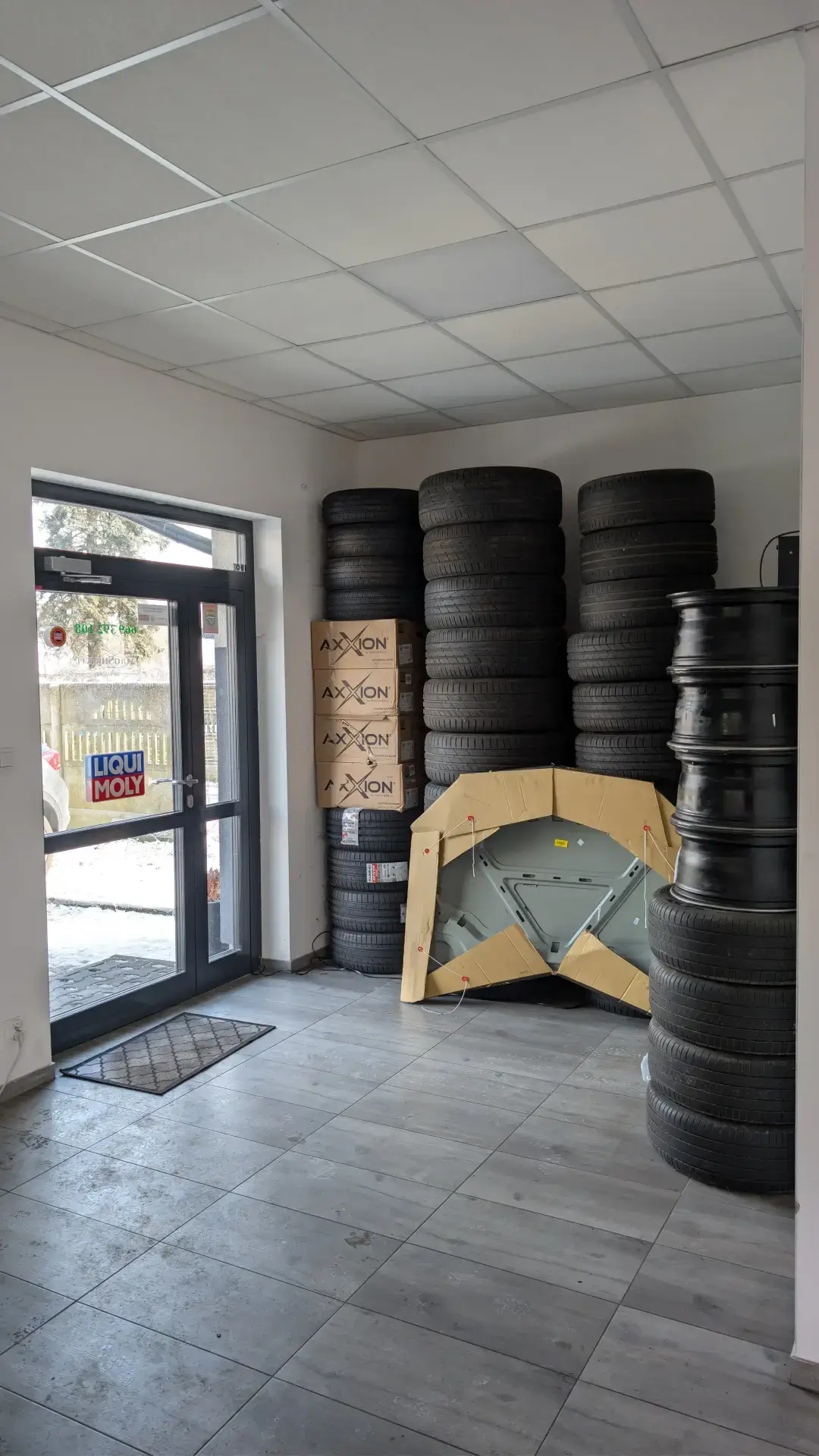 Magazyn serwisu z nowymi oponami, felgami aluminiowymi marki Axxion oraz częściami karoserii gotowymi do montażu.